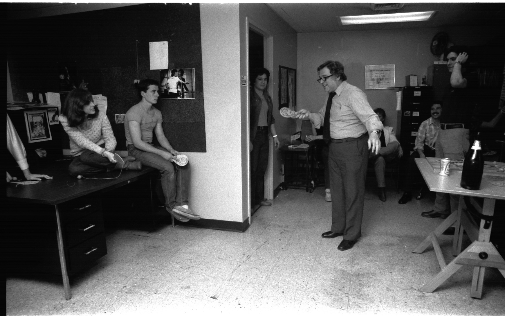 Jazzy Johnny Romita, on staff Art Director, perhaps the greatest penciler/inker who ever took a magnifying glass to a page and generally regarded as the nicest guy in comics-- cannot seem to see the ball for very long. His son, John "JR-JR" Jr., looks on from the doorway, with familial affection.