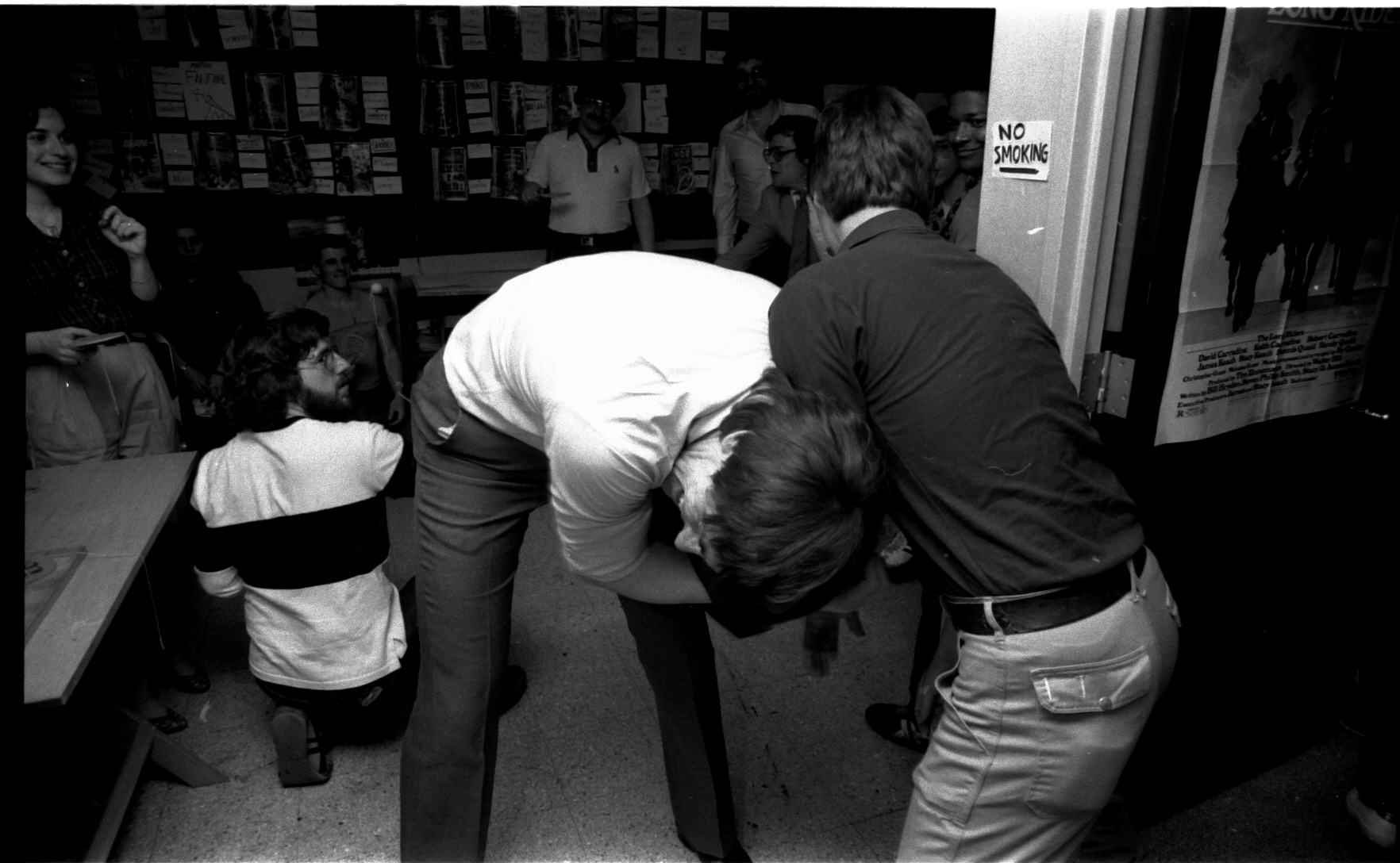 What an upset! Jim Shooter dives in to save all of us. Like throwing himself on a live grenade-- he wrestles with Bob "Master of Kung Fu" Layton (no, he never inked MOKF, but it sounds great) to snatch the ball. Ron Zalme looks on aghast. Belinda is highly amused at these two's antics. One can now see the "No Smoking" sign that Bob lights his matches on.